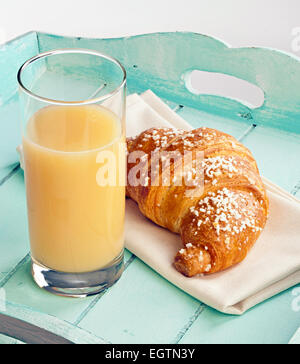 Croissant et jus de poire sur le bleu clair. Banque D'Images