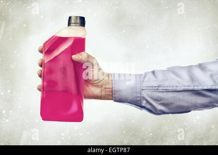 Homme main tenant une bouteille d'additif antigel liquide à base d'eau Banque D'Images