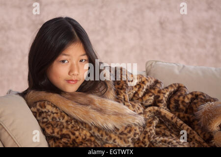 Très belle fille chinoise, posant à l'appareil photo, habillé avec des vêtements ethniques, portant à un coach. Banque D'Images