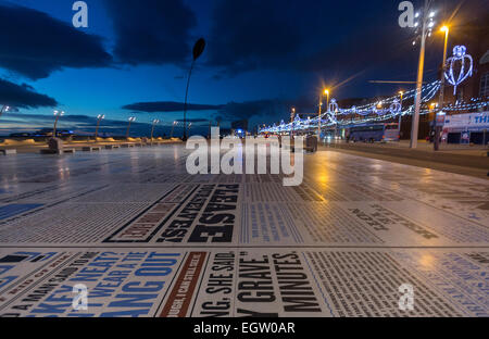 Promenade avec journal dans Blackpool. Illuminations de nuit avec la tour illuminée Banque D'Images