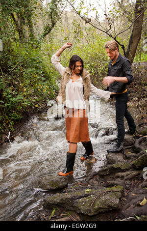 Femme waling voyage creek avec l'homme derrière elle. Banque D'Images