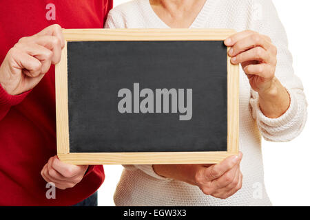 Vieux couple holding empty tableau noir dans les mains Banque D'Images