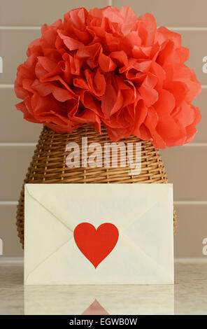 Panier Vase avec du papier rouge pom pom fleur et une lettre d'amour sur le comptoir de cuisine Banque D'Images