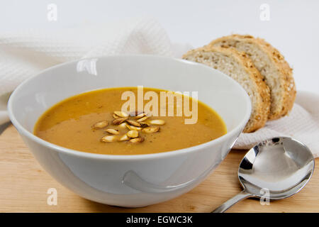 Rôti maison épicée potage à la courge musquée graines de courge grillées arrosé sur le dessus, dans un bol blanc Banque D'Images