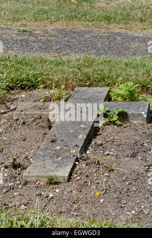 Pierre tombale croix qui a rompu et tombés dans la terre au cimetière de Bedford, Foster Hill Road, Bedford, Bedfordshire, Angleterre Banque D'Images