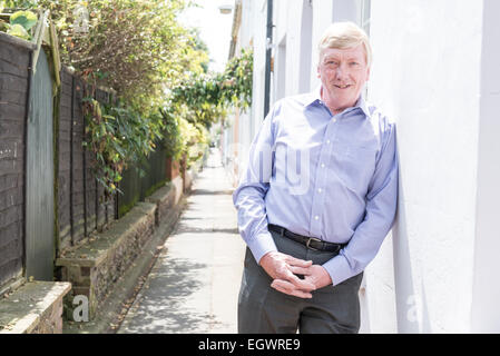 Un senior, homme d'affaires à la retraite pose devant sa voiture classique, murs, escalier et urbain autour de la ville, dans une chemise ouverte Banque D'Images