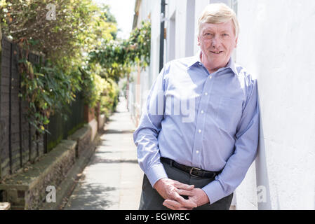 Un senior, homme d'affaires à la retraite pose devant sa voiture classique, murs, escalier et urbain autour de la ville, dans une chemise ouverte Banque D'Images