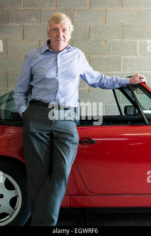 Un senior, homme d'affaires à la retraite pose devant sa voiture classique, murs, escalier et urbain autour de la ville, dans une chemise ouverte Banque D'Images