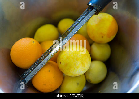 Close up détails des déserts de fruits réalisés dans une cuisine professionnelle par un chef expert. Râper le zeste d'une orange et citrons Banque D'Images