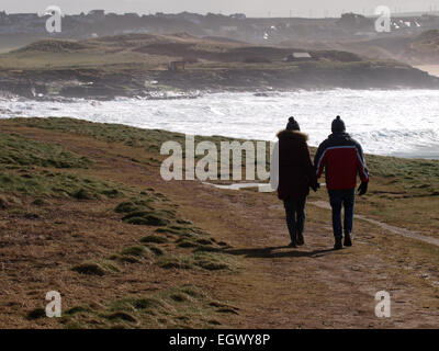 Couple d'âge moyen à marcher le long de la côte sud-ouest en hiver, chemin des's Bay, Cornwall, UK Banque D'Images
