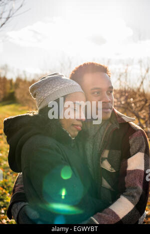 Deux personnes, un couple en train de marcher dans un verger en hiver. Banque D'Images