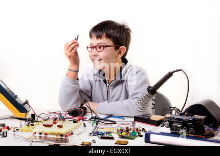 Jeune étudiant effectue des expériences dans l'électronique et des rêves de l'avenir. Banque D'Images