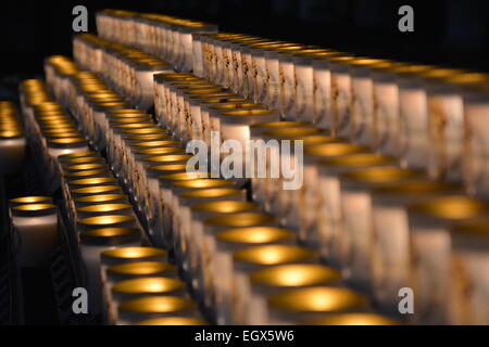 Tableau dramatique d'un grand nombre de bougies allumées dans une rangée Banque D'Images