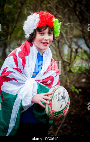 Garçon drapé dans le drapeau gallois Welsh Rugby supporters habillés de regarder London Welsh jouer sur St.Davids Day Banque D'Images