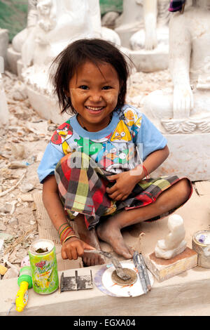 Une jeune fille travaillant dans une boutique de la préparation les statues de bouddha à vendre, Mandalay, Myanmar ( Birmanie ), l'Asie Banque D'Images