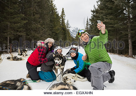 En famille avec des chiens de traîneau à chiens en selfies snow