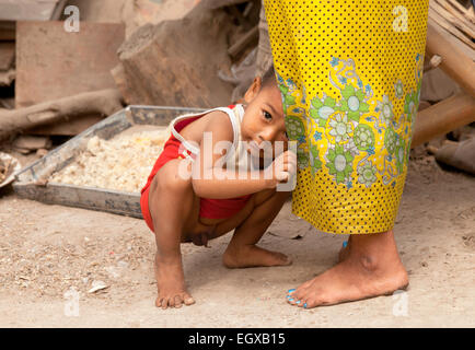 Enfant timide garçon birman mères caché dans sa jupe, Mandalay, Myanmar ( Birmanie ), l'Asie Banque D'Images