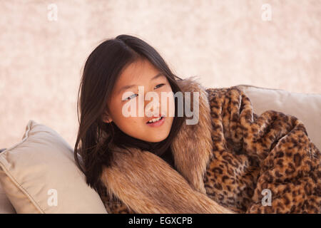 Belle fille chinoise, habillé avec un manteau ethnique, poser et jouer en face de la caméra. Banque D'Images