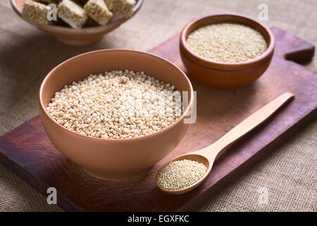 Le quinoa blanc sauté (lat. Chenopodium quinoa) dans un bol de céréales avec des graines de quinoa quinoa et les barres de céréales dans le dos Banque D'Images