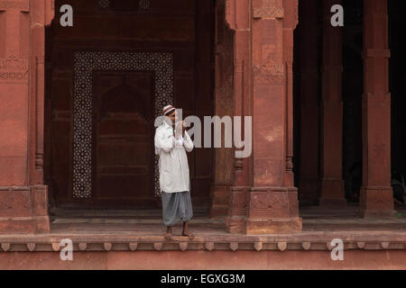 Homme debout musulmane par une colonne à Fatehpur Sikri, Uttar Pradesh, Inde Banque D'Images