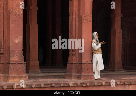 Homme debout musulmane par une colonne à Fatehpur Sikri, Uttar Pradesh, Inde Banque D'Images