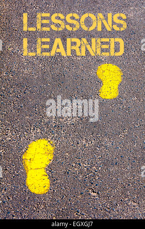 Traces jaunes sur trottoir vers les enseignements tirés message.Conceptual image Banque D'Images