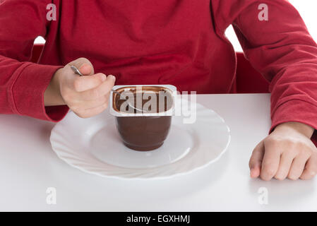 Petite fille manger une crème au chocolat isolé sur fond blanc Banque D'Images