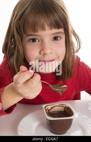 Petite fille manger une crème au chocolat isolé sur fond blanc Banque D'Images