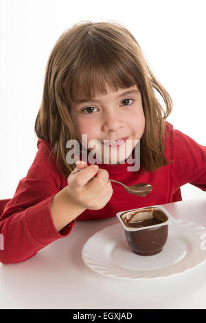 Petite fille manger une crème au chocolat isolé sur fond blanc Banque D'Images