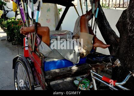 Hua Hin, Thaïlande : chauffeur de taxi Tuk-Tuk thaïlandais prend une sieste dans son véhicule en attendant les clients Banque D'Images