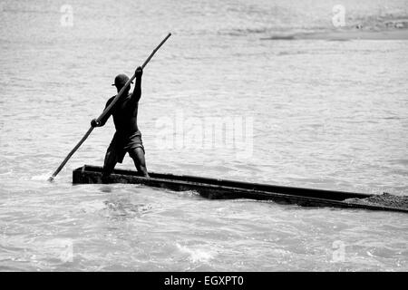 Un mineur, à l'aide d'un sable barge totémique, navigue sur son bateau chargé avec extrait du sable dans la rivière à Cartago, Colombie. Banque D'Images