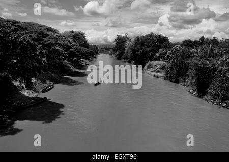 Sable colombien les mineurs, à l'aide d'une barge totémique, naviguer leurs bateaux chargés de sable extrait dans la rivière à Cartago, Colombie. Banque D'Images