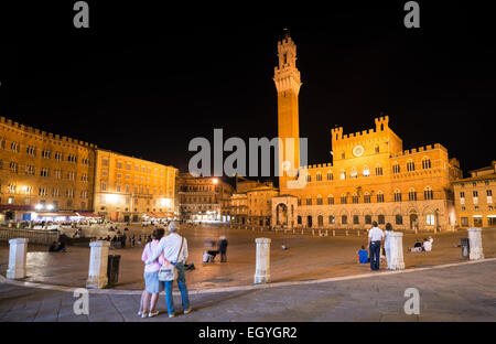 Les touristes au Palazzo Pubblico avec Tour du Mangia illuminée et chapelle, nuit, Piazza Il Campo, Sienne, Toscane, Italie Banque D'Images