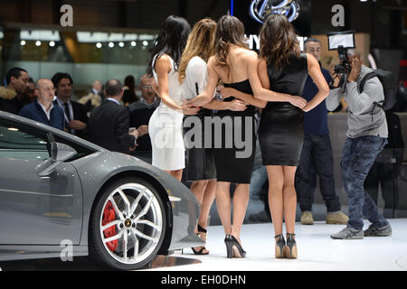 Genève, Suisse. 4e Mar, 2015. Un homme prend des photos de quatre hôtesses au stand de Lamborghini au Palexpo parc d'un jour avant l'ouverture officielle du 85e Salon International de l'Automobile à Genève, Suisse, le 4 mars 2015. Le 85e Salon International de l'Automobile de Genève se déroulera du 05 au 15 mars 2015. Photo : Felix Kaestle/dpa/Alamy Live News Banque D'Images