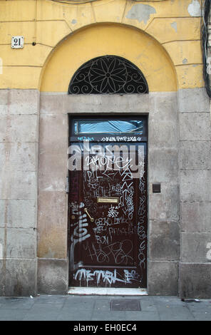 Vieille porte couverts de graffitis dans le quartier El Raval run dans le centre de Barcelone, Catalogne, Espagne. Banque D'Images