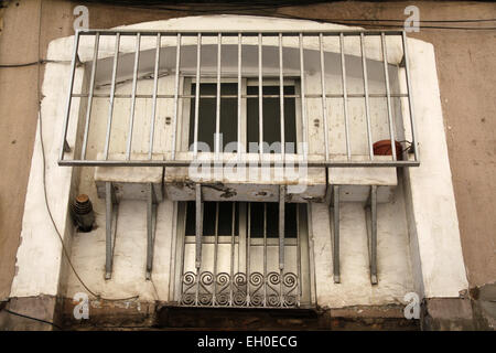 Vieille porte fenêtre avec des bars dans le quartier El Raval, dans le centre de Barcelone, Catalogne, Espagne. Banque D'Images