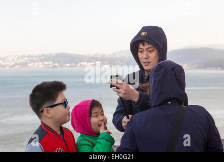 Asian man, à l'aide de bâton selfies, photo selfies, vista point, côté nord du golden gate bridge, de la ville de Sausalito, Sausalito, Californie Banque D'Images