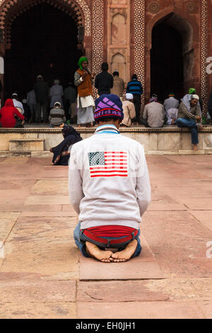 Un musulman, dans un Stars and Stripes shirt, priant à la prière du vendredi, la Mosquée Jama Masjid, Fatehpur Sikri, Agra, Uttar Pradesh, Banque D'Images