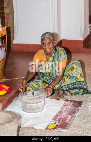 Vieille Femme portant un style local de la farine de riz par meulage sari méthodes traditionnelles à DakshinaChitra Heritage Museum, Chennai, Tamil Nadu, Inde du sud Banque D'Images