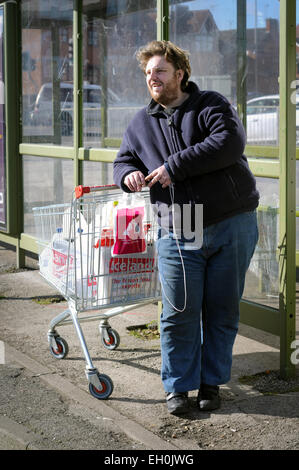 Homme avec Shopping attendre à l'arrêt de bus . Banque D'Images