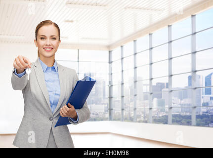 Smiling businesswoman with folder et clés Banque D'Images