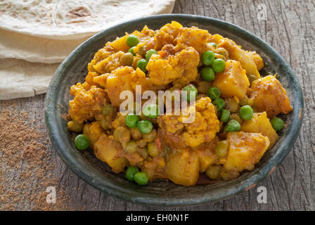 Le chou-fleur et de pommes de terre sur une table en bois curry servi avec chapattis. Banque D'Images