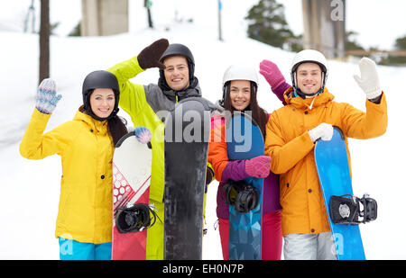 Happy friends dans casques avec snowboards Banque D'Images