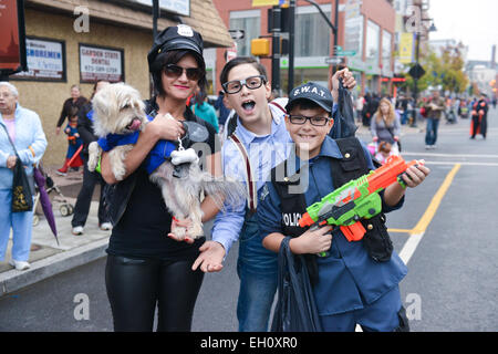 Deux jeunes enfants posant avec une jeune femme qui tient un chien à l'Halloween 2013 dans les rues de Newark, New Jersey USA. Banque D'Images