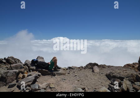 En appui sur le sommet du Mont Taranaki au-dessus des nuages Banque D'Images