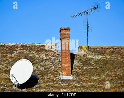 La parabole et antenne de télévision sur le toit d'un immeuble ancien Banque D'Images