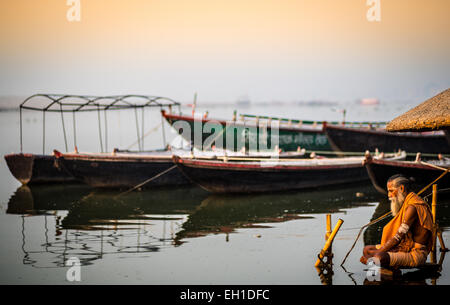 Un dévot hindou assis par le Gange à Varanasi, méditant dans le lever du soleil. Banque D'Images