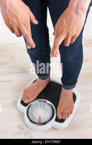 Femme debout sur les balances avec Fingerrs ont franchi Banque D'Images