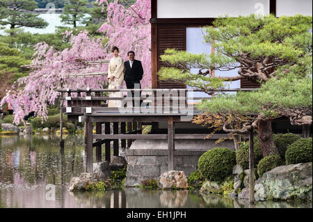 Visiteurs admirant la fleur de cerisier printanière près du lac dans les jardins du 19c du sanctuaire Heian (Heian Jingu), un temple shinto à Kyoto, au Japon Banque D'Images