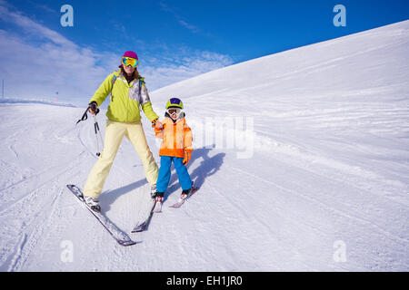 La mère et le petit garçon l'apprentissage du ski holding hand Banque D'Images